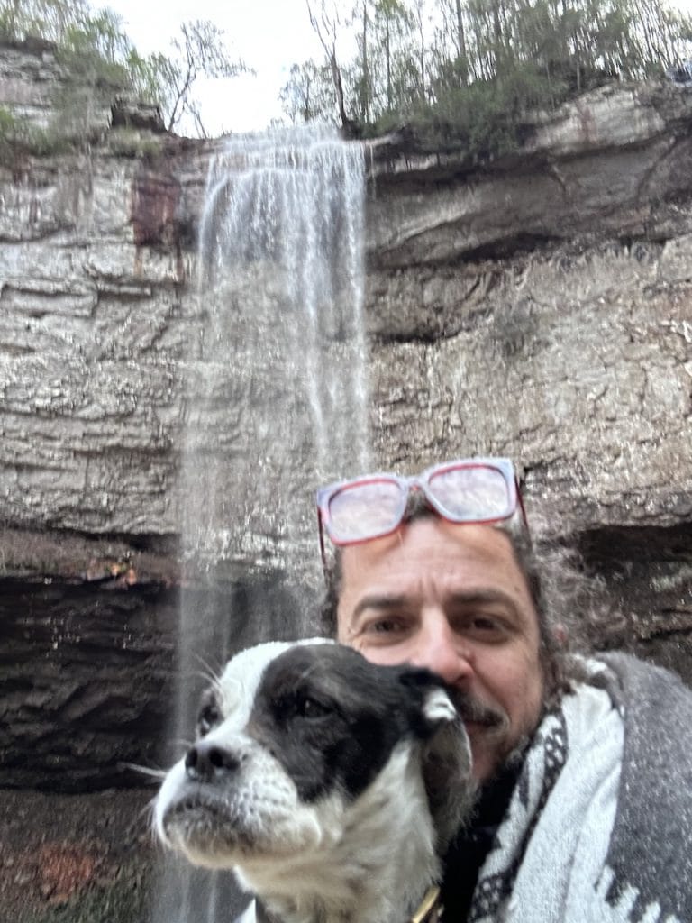 Ben Hoffman and his dog Otto taking a selfie in front of a waterfall